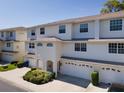 Charming townhome with a white exterior, well-manicured landscaping, and a two-car garage at 8181 Eagles Park N Dr, St Petersburg, FL 33709