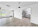Open living room with sleek gray flooring and an entrance to the updated kitchen at 8451 81St Way, Seminole, FL 33777