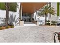 Inviting covered entrance showcases the building's grand design with palm trees and pavers leading to the front door at 1020 Sunset Point Rd # 410, Clearwater, FL 33756