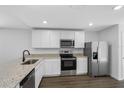 A well-lit kitchen showcasing white cabinets, granite countertops, and stainless steel appliances at 11199 Murraysville Dr, Spring Hill, FL 34609