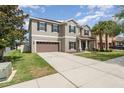 Two-story home with a spacious driveway leading to an attached two-car garage and a well-maintained front yard at 11206 Coventry Grove Cir, Lithia, FL 33547