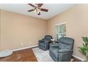 Cozy living room features two comfortable armchairs, a ceiling fan, hardwood floors and a natural light at 11206 Coventry Grove Cir, Lithia, FL 33547