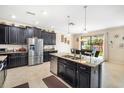 Spacious kitchen featuring a central island, stainless steel appliances, and plenty of cabinet space at 11802 Twilight Darner Pl, Riverview, FL 33569
