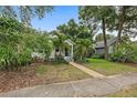 Charming home with mature tropical landscaping and a walkway leading to the inviting, covered front porch at 1211 14Th N St, St Petersburg, FL 33705