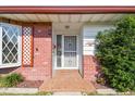 Inviting entryway with brick accents, decorative window lattice, and a secure white security screen door at 1436 Santa Clara Dr, Dunedin, FL 34698