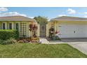 Charming yellow home with a well-manicured lawn and beautiful landscaping at 15005 Roundup Dr, Tampa, FL 33624
