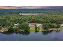 An aerial view highlights the property's lakefront location, surrounded by dense trees and tranquil waters at 16112 N 15Th St, Lutz, FL 33549