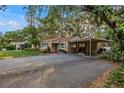 Charming single-story home features a large driveway, carport, mature landscaping and mature shade trees at 1753 San Mateo Dr, Dunedin, FL 34698