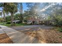 Charming single-story home features a large driveway, carport, mature landscaping and mature shade trees at 1753 San Mateo Dr, Dunedin, FL 34698