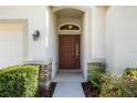 Inviting front entrance with a beautiful wooden door, stone accents, and lush landscaping at 203 Montara Dr, Seffner, FL 33584