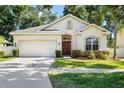 Charming single-story home with a manicured lawn, a two-car garage, and a welcoming entrance at 203 Montara Dr, Seffner, FL 33584