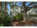 Exterior angle featuring an attractive two-story home with mature trees and lush plants at 215 18Th Ave, Indian Rocks Beach, FL 33785