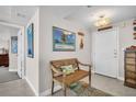 Inviting entryway with neutral paint, tile floor, a wooden bench, and coastal decor at 223 Island Way # 7F, Clearwater Beach, FL 33767
