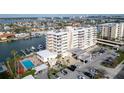 Elegant condo building featuring a pool, boat slips, and well-maintained landscaping at 223 Island Way # 7F, Clearwater Beach, FL 33767
