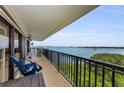 Spacious balcony overlooking beautiful water views with seating and black metal railings at 2700 Bayshore Blvd # 11405, Dunedin, FL 34698