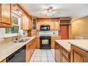 Kitchen featuring wooden cabinetry, tile backsplash, black appliances, and an island for food preparation at 2911 Pemberton Creek Dr, Seffner, FL 33584