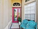 A colorful entryway with a vibrant red door and ornate blue chairs offering an inviting welcome at 3402 Stonebridge Trl, Valrico, FL 33596