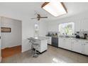 Bright kitchen with white cabinets, stainless steel appliances, and a cozy breakfast bar for casual dining at 37420 Teaberry Loop, Zephyrhills, FL 33542