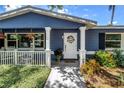 A charming home exterior featuring a cozy front porch with decorative columns and vibrant landscaping at 5947 46Th N Ave, Kenneth City, FL 33709