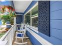 Inviting front porch with rocking chairs, hanging plants, and decorative accents at 5947 46Th N Ave, Kenneth City, FL 33709