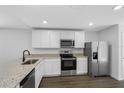 Modern kitchen featuring stainless steel appliances, granite countertops, and ample cabinet space for storage at 6260 Pinehurst Dr, Spring Hill, FL 34606
