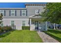 Classic two-story townhouse featuring a covered porch, complemented by a neatly manicured lawn, creating an inviting facade at 6619 S Manhattan Ave # 1, Tampa, FL 33616