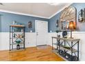 Stylish entryway featuring hardwood floors, soft blue walls, and decorative shelves with elegant decor at 708 Westwood Cir, Brandon, FL 33511