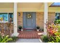 Close-up of a beautiful front door with a wreath, flanked by decorative columns and vibrant plants at 708 Westwood Cir, Brandon, FL 33511