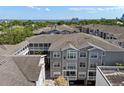 Aerial view of condo buildings with gray exteriors, light-colored roofing, and a water view in the distance at 800 S Dakota Ave # 337, Tampa, FL 33606