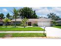 Beautiful single-story home with a well-maintained lawn, mature palms, and a two-car garage at 8060 Canterbury Cir, Seminole, FL 33777