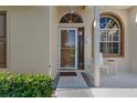 The beautiful front entrance features sidelight windows, tile flooring, and manicured landscaping at 9314 Alta Sol Way, New Port Richey, FL 34655