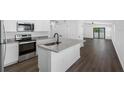 Modern kitchen open to living area featuring stainless appliances, granite countertops, and island with sink at 9471 Eldridge Rd, Spring Hill, FL 34608