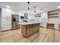 Bright, modern kitchen with stainless steel appliances, white cabinets, and a large island at 9580 130Th Ave, Largo, FL 33773