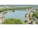 Aerial view of a home with a lake view, surrounded by lush greenery and a neighborhood at 9721 Fredericksburg Rd, Tampa, FL 33635