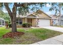Charming single-story home with a well-manicured lawn, neutral paint, and an attached two-car garage at 9721 Fredericksburg Rd, Tampa, FL 33635