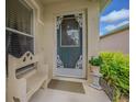 Inviting front porch features decorative door, charming bench, and lush landscaping at 10801 Collar Dr, San Antonio, FL 33576