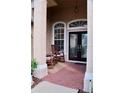 Inviting front porch featuring double doors, brick flooring, and comfortable rocking chairs at 10908 Sailbrooke Dr, Riverview, FL 33579