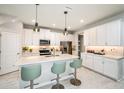 Bright kitchen with white cabinets, quartz countertops, stainless steel appliances, and modern pendant lighting at 1124 Creek Valley Ct, Brandon, FL 33511