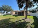 Spacious backyard featuring lush green grass, a screened-in lanai, and a secure white fence at 11420 Bridge Pine Dr, Riverview, FL 33569