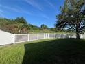 Large, private backyard with a white picket fence and scenic views of trees and greenery at 11420 Bridge Pine Dr, Riverview, FL 33569