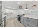 Modern eat-in kitchen featuring stainless steel appliances, light gray cabinets, and light-colored flooring at 1470 Serpentine S Dr, St Petersburg, FL 33705