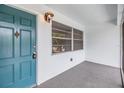 Inviting entryway featuring a teal door, ample lighting, and a secure lock system at 1485 Lakeview Rd # 19, Clearwater, FL 33756