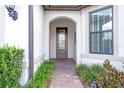Leaded glass front door with sidelight surrounded by green landscaping and a brick walkway at 16723 Blackwater Ter, Bradenton, FL 34202