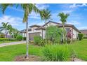 Tastefully landscaped front yard with palm trees, flowers, and a brick driveway at 16723 Blackwater Ter, Bradenton, FL 34202