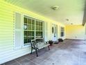 Covered porch featuring a decorative bench, tiled floor, and white columns that add charm at 1914 Henley Rd, Lutz, FL 33558