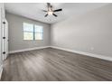 Serene bedroom featuring neutral walls, wood flooring, a ceiling fan, and a large window at 2330 Hiers Rd, Dover, FL 33527