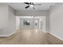 Bright and airy living room features modern light fixture and wood flooring at 2402 Hiers Rd, Dover, FL 33527