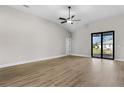 Bright living room featuring wood floors, ceiling fan, and sliding doors to the backyard at 2414 Hiers Rd, Dover, FL 33527