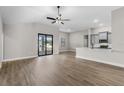 Open-concept living space featuring wood floors and a kitchen bar with grey cabinets and white countertops at 2414 Hiers Rd, Dover, FL 33527