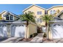 Townhome exterior featuring attached garage, well-kept lawn, and inviting front entrance at 2648 Sabal Springs Dr # 2, Clearwater, FL 33761